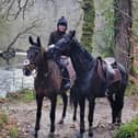 Bryony riding Frodon with Black Corton besides the River Dart. Credit: Bryony Frost