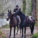 Bryony riding Frodon with Black Corton besides the River Dart. Credit: Bryony Frost