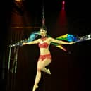 A performer takes to the air during an aerial silks routine at Circus Brazil, currently running on Paignton Green