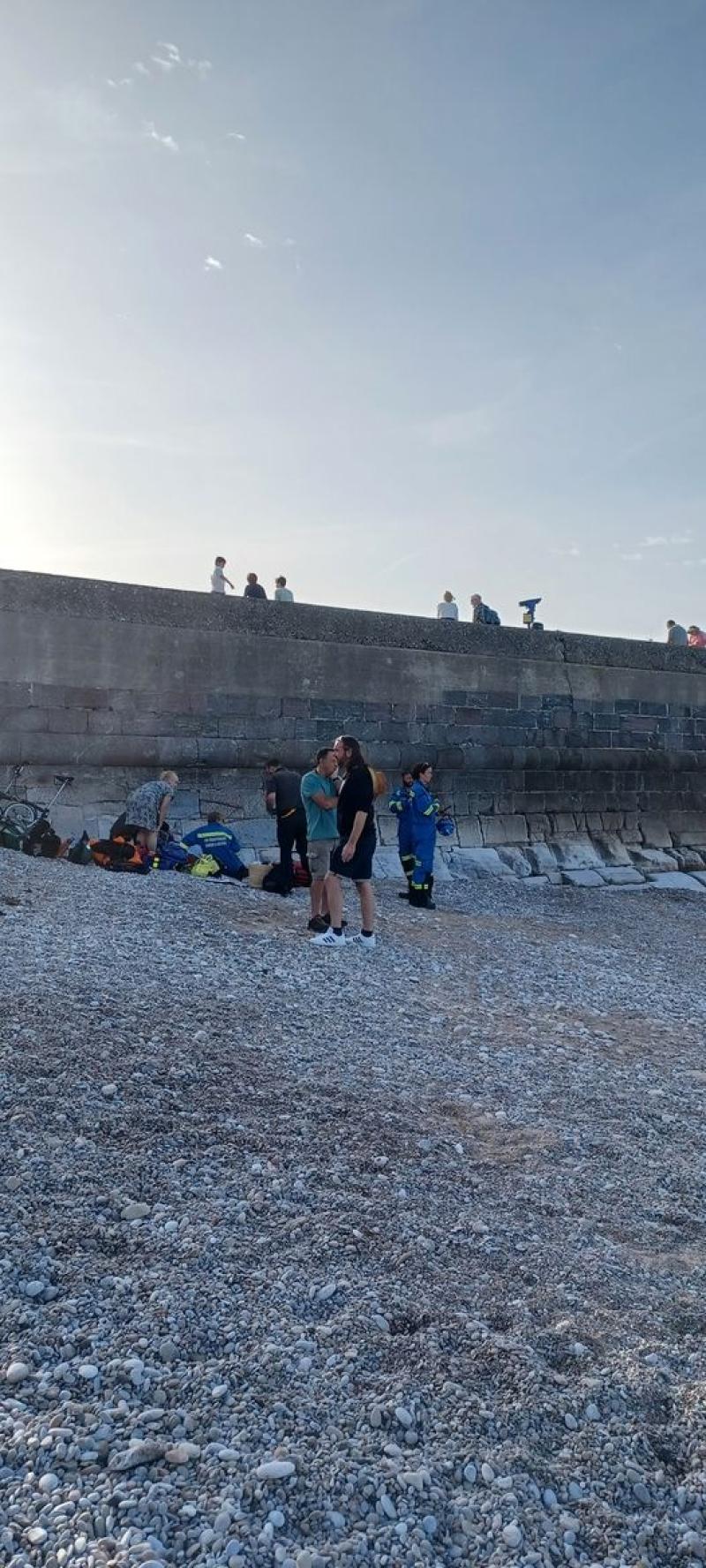 Paramedic and injured boy on beach