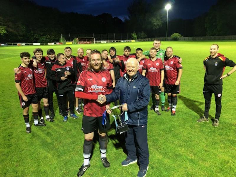 Bovey Tracey captain Ryan Stanbridge being presented the Division Two champions cup by League secretary Alastair Muirden
