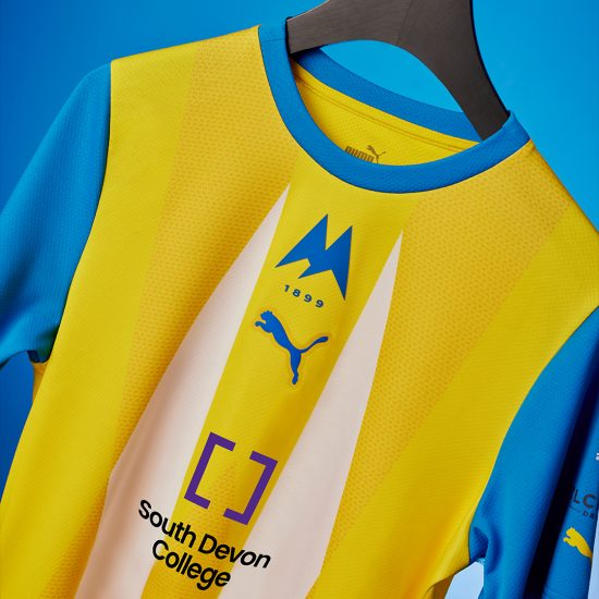 Torquay United's home shirt with the college logo
