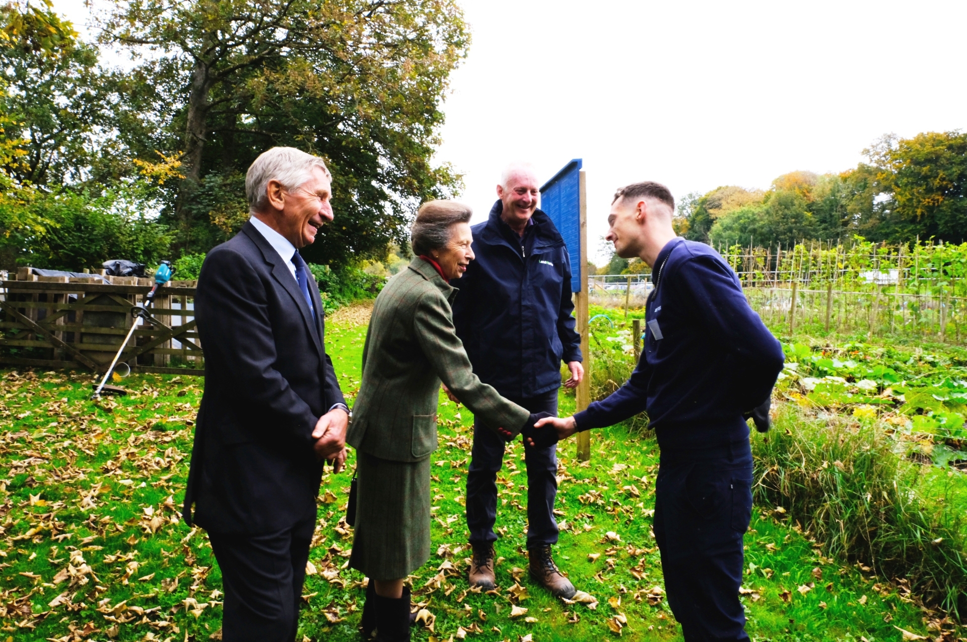 Princess Anne meeting a trainee at the LandWorks market garden with Ted Tuppen, left, and Chris Parsons, right