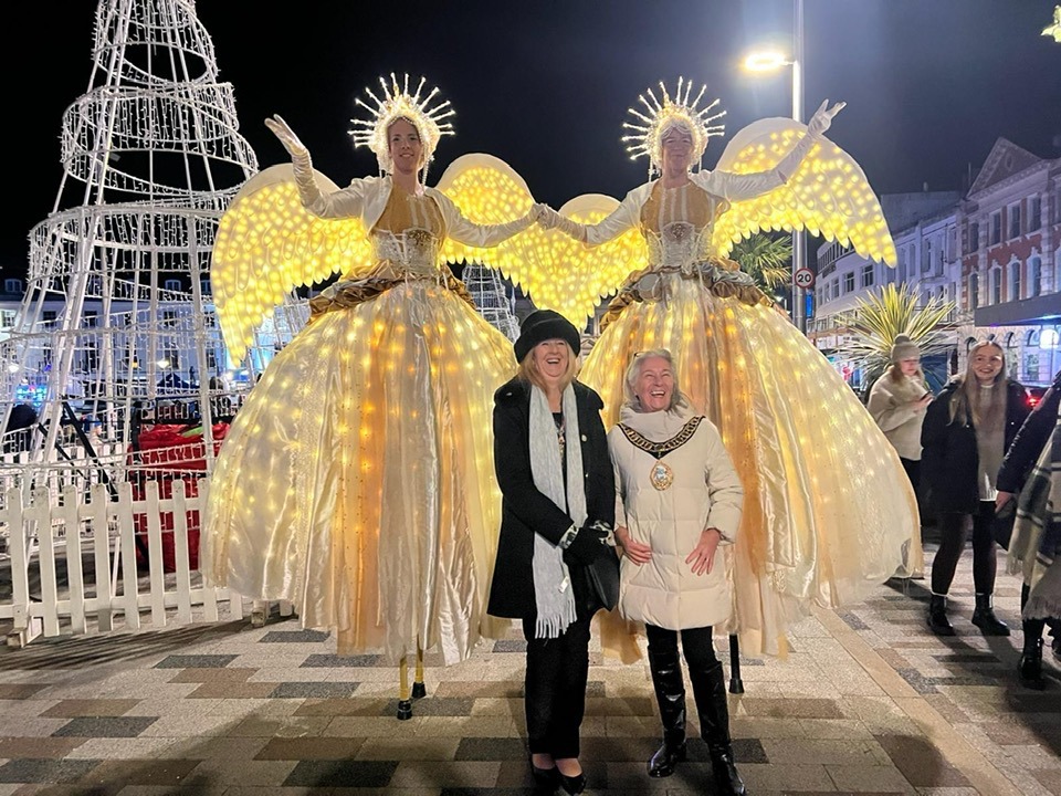 Bay of Lights - the long and short of it, councillor Jackie Thomas (left) and mayor Barbara Lewis with festive street entertainers