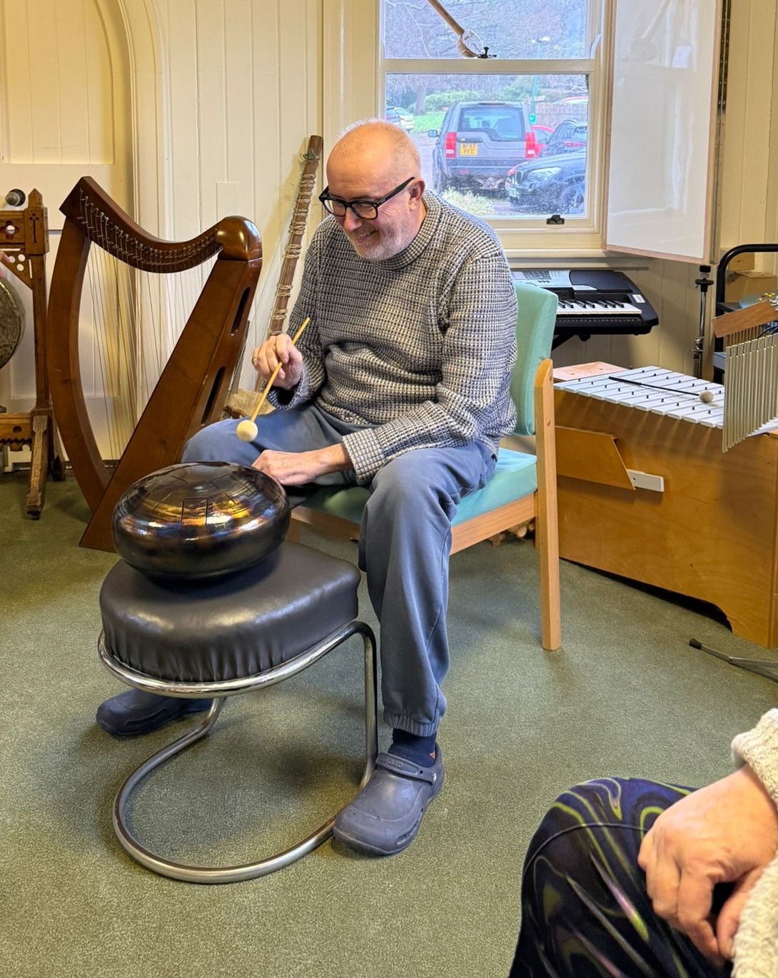 Richard Goss playing a tongue drum in a music therapy session at Rowcroft Hospice