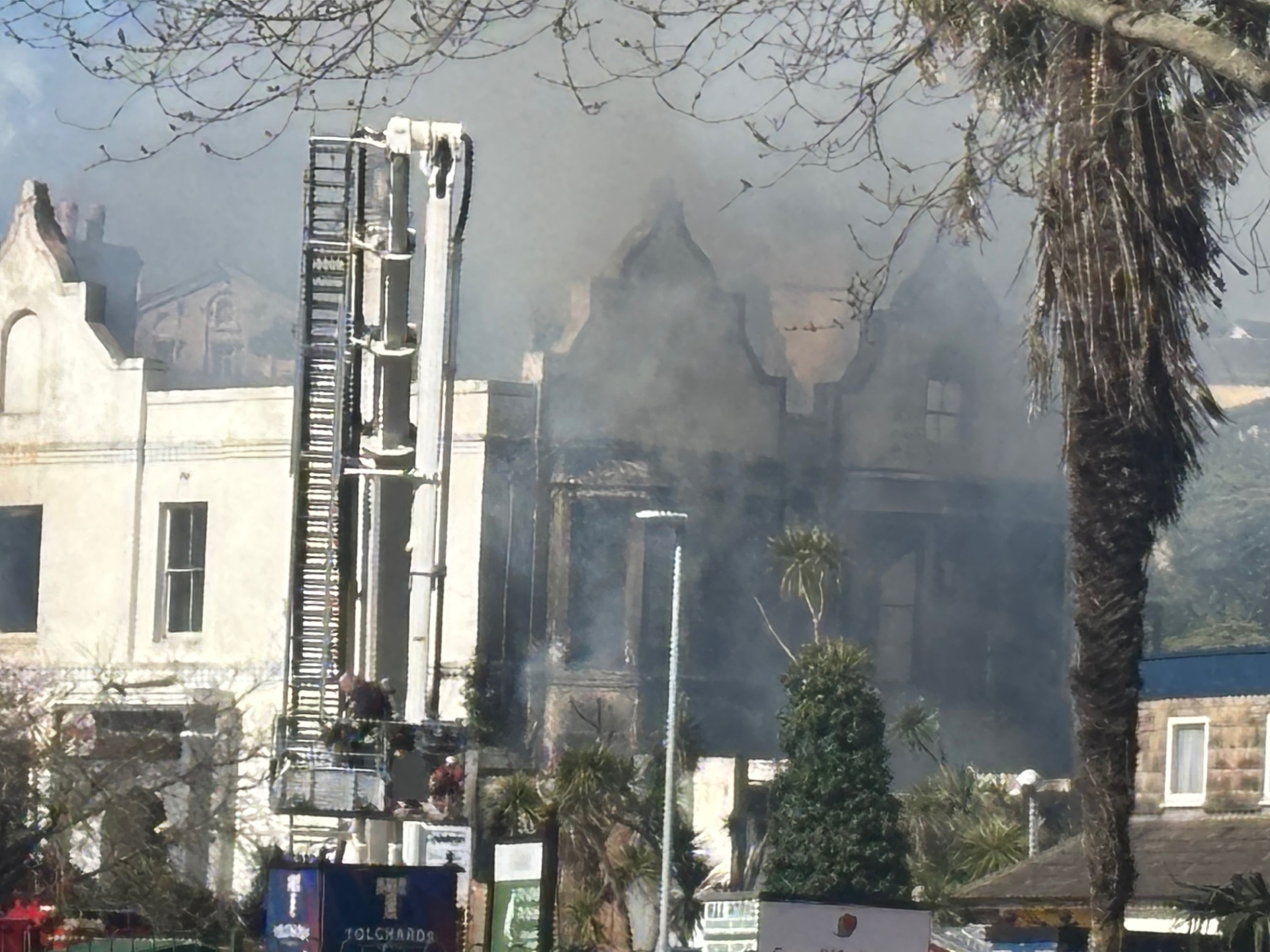 The roof of the Sherwood Hotel is destroyed by the flames