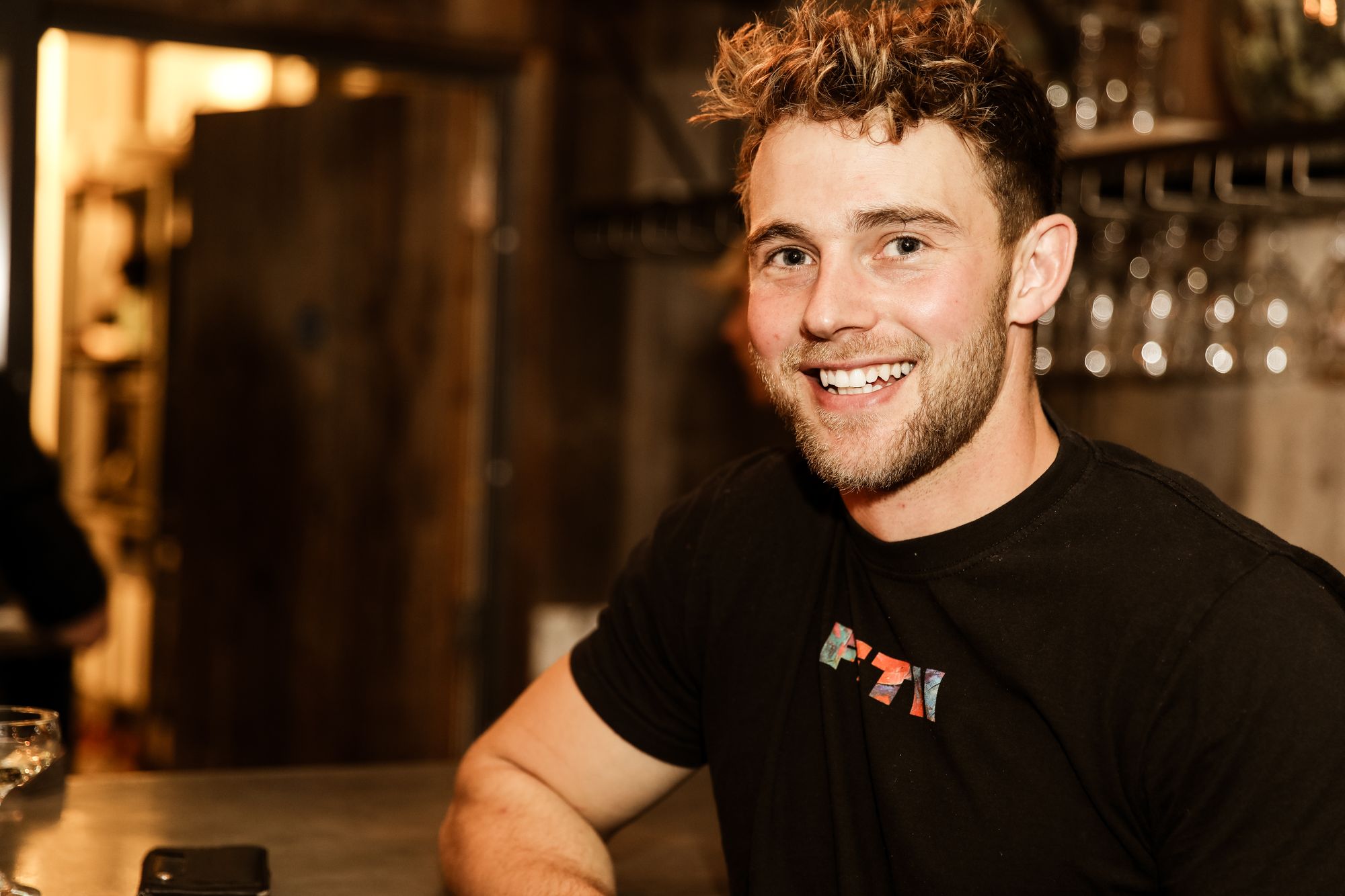young man in black t-shirt smiling at camera