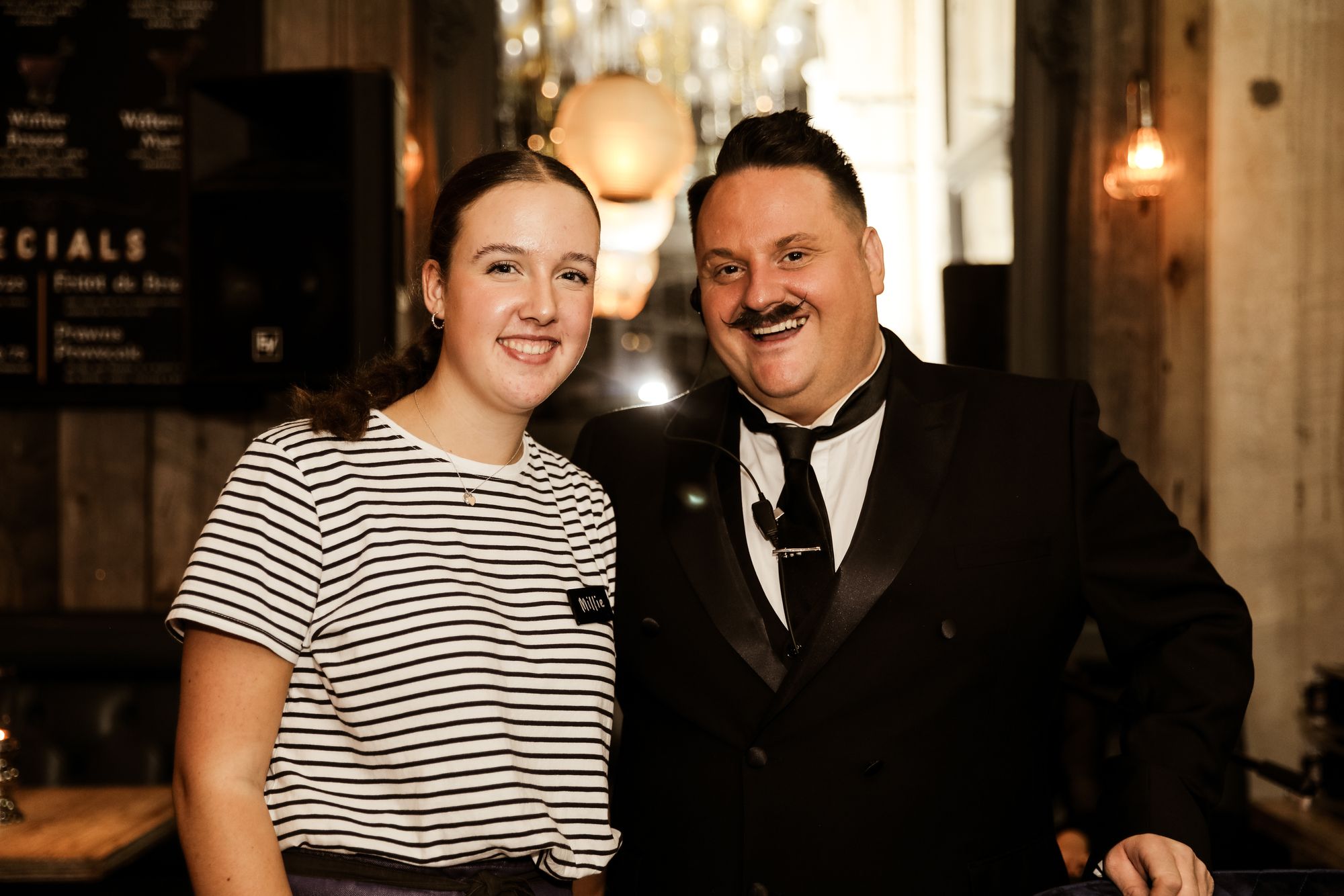 woman in stripey black and white top and man dressed in black suit, white shirt