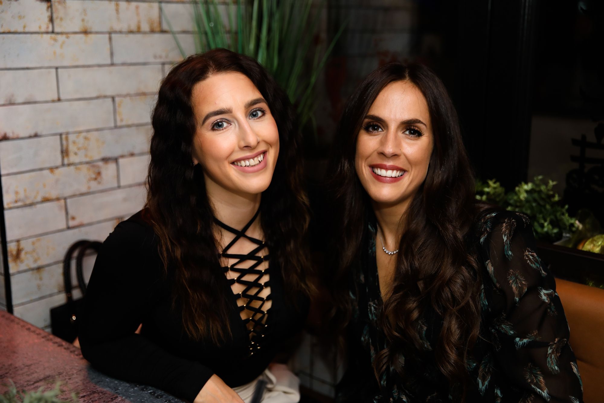 Two dark-haired young women smiling at the camera