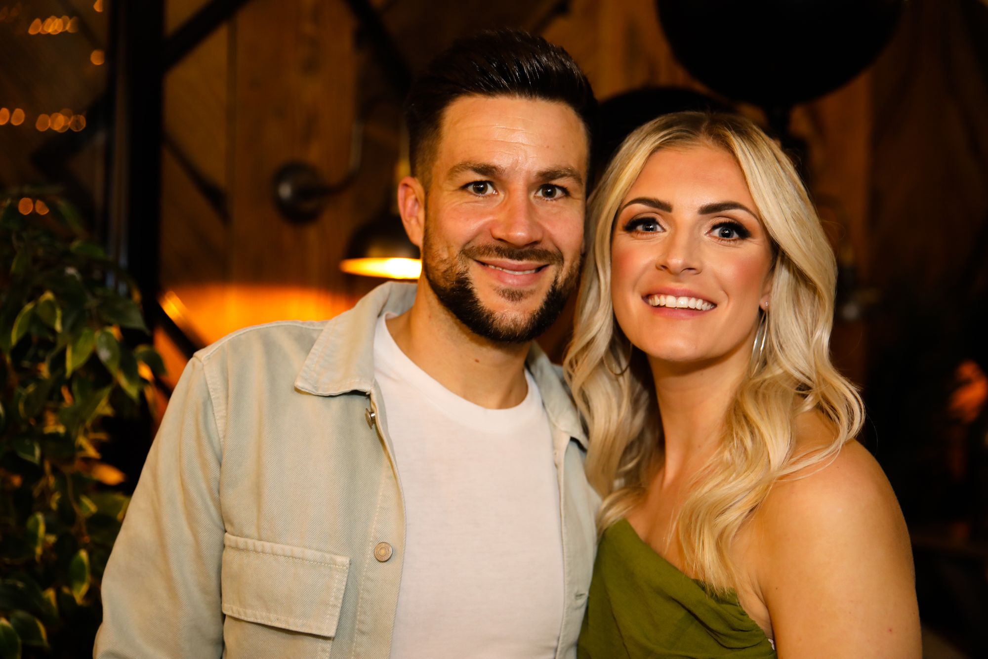 A blonde woman and dark-haired man smiling