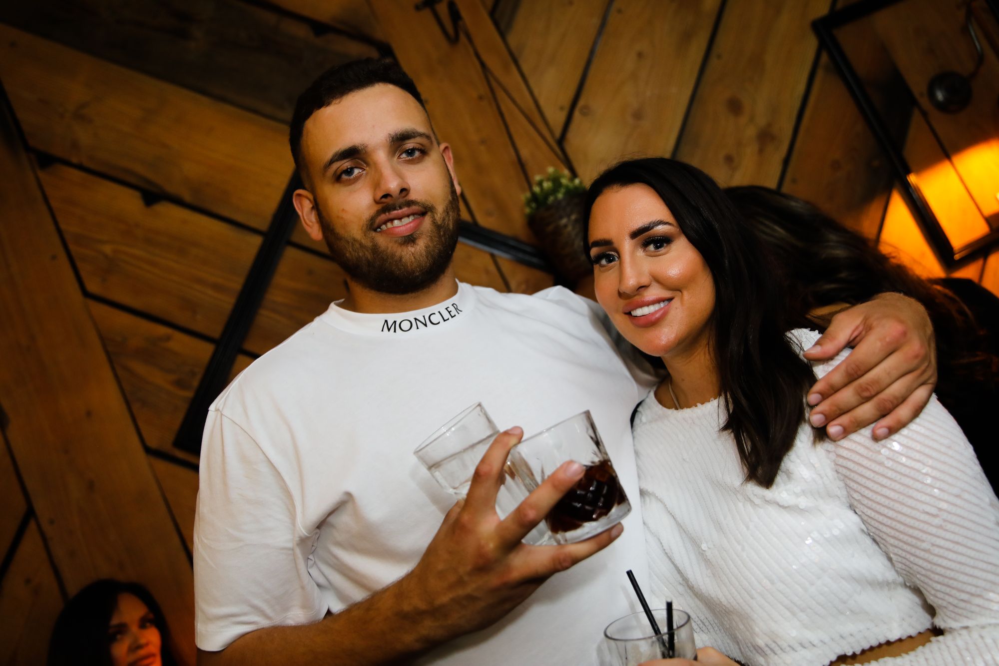 A young couple, both wear8ing white tops, smiling at the camera