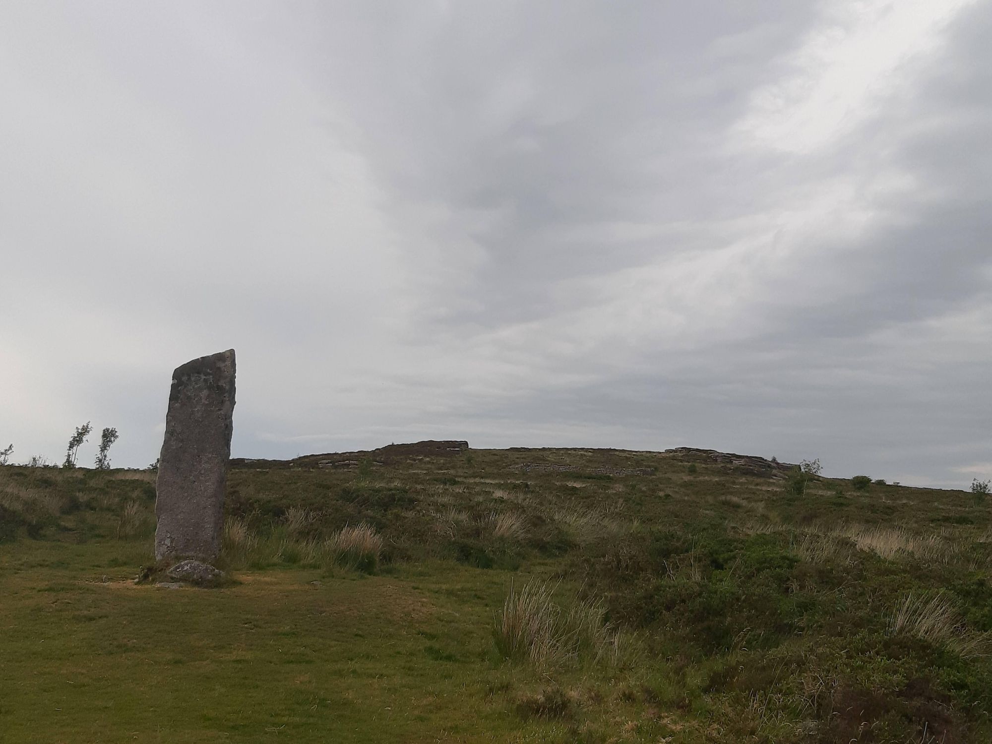 Laughter/Loughtor Man standing stone with Laughter Tor behind. Credit: David Phillips