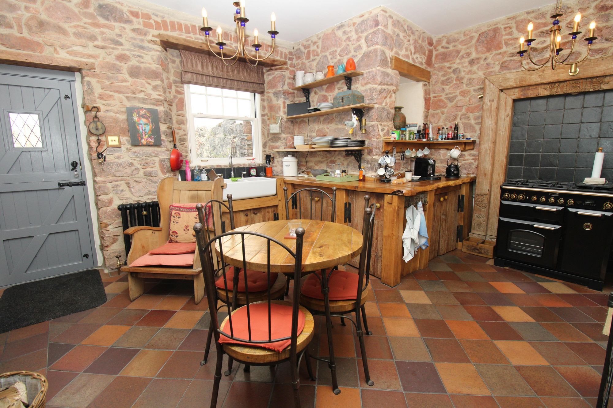 The kitchen/breakfast room with bespoke kitchen, log burner and exposed stone walls. Credit: Amanda Ayshford